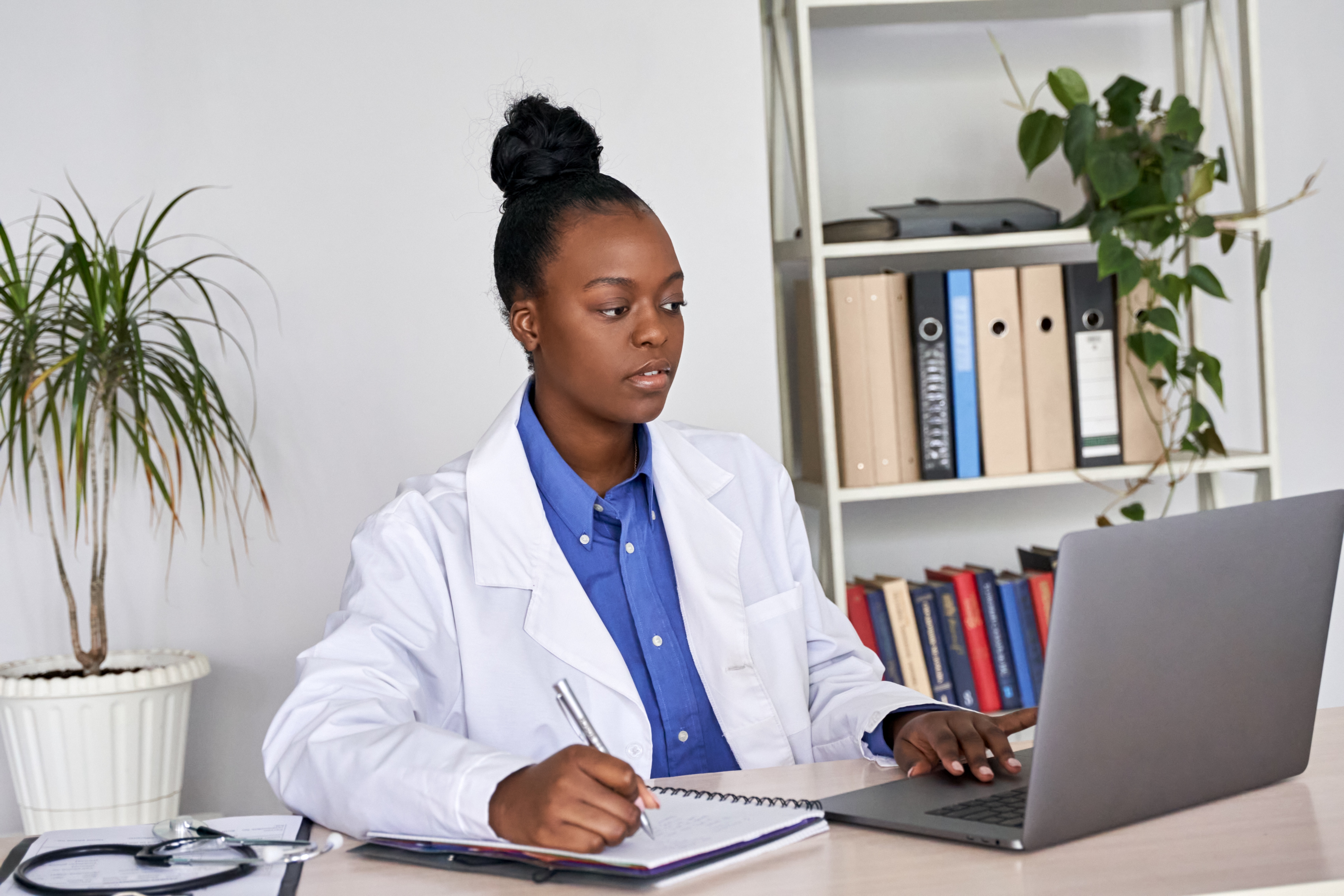 Student studying with laptop and taking notes