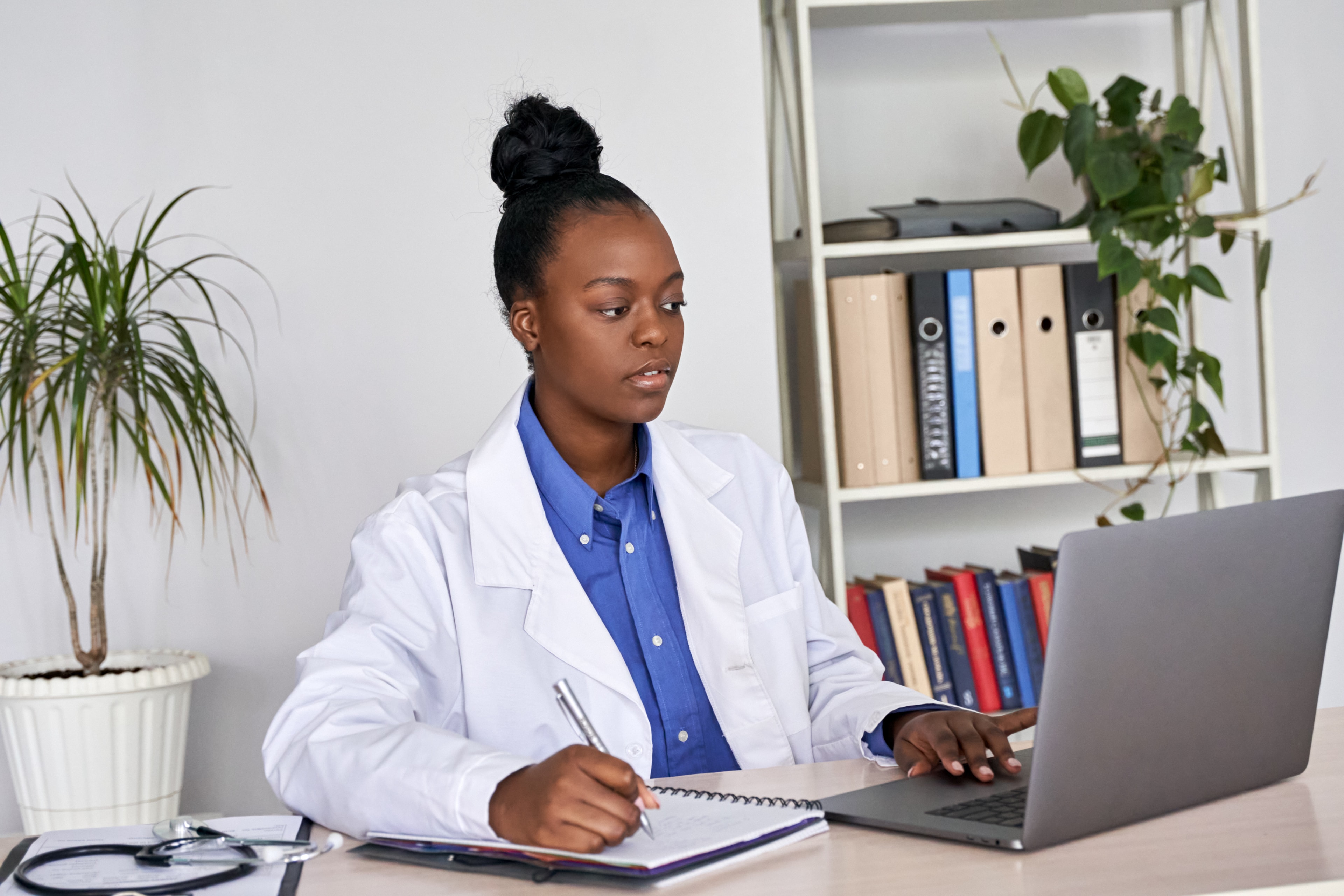 Student studying with laptop and taking notes